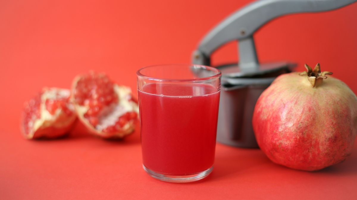Glas Granatapfelsaft mit Granatapfel als Symbol für Ernährung bei Kinderwunsch
