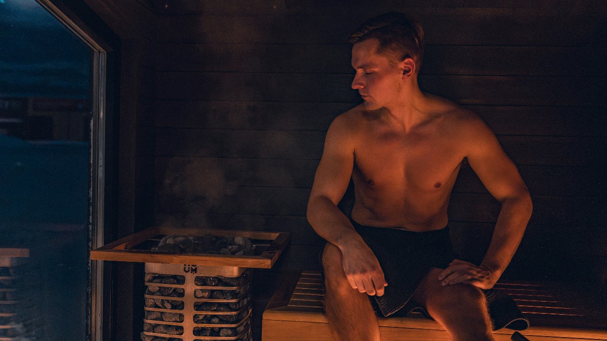 Mann sitzt in einer Sauna als Symbol für Hitze und ihren möglichen Einfluss auf die Spermienqualität