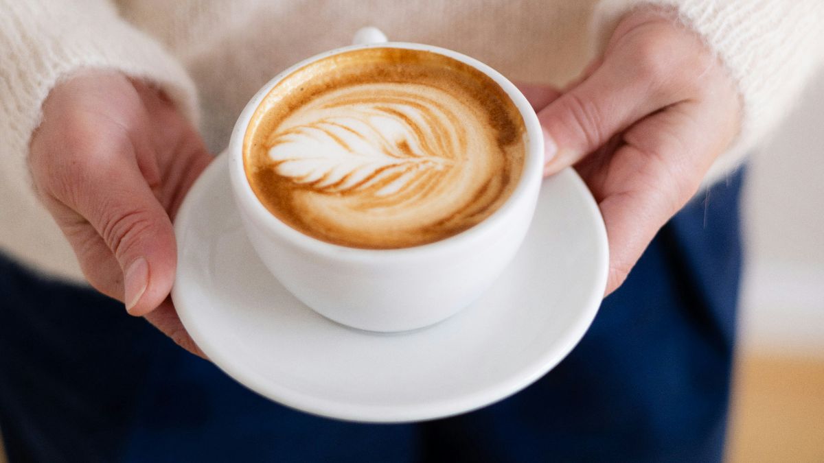 Tasse Kaffee in den Händen als Symbol für Koffein bei Kinderwunsch