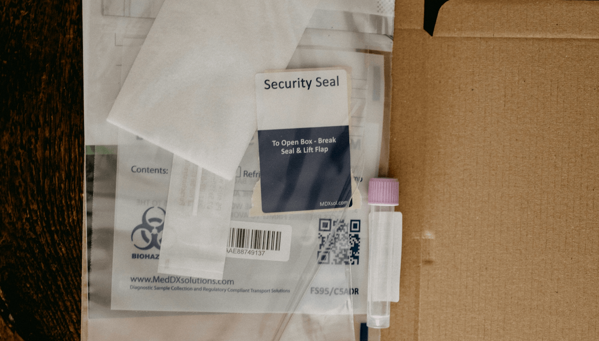 Geöffneter Versandkarton mit Probenröhrchen, Versandmaterial und Testkit für einen Fruchtbarkeits- oder Heimtest.