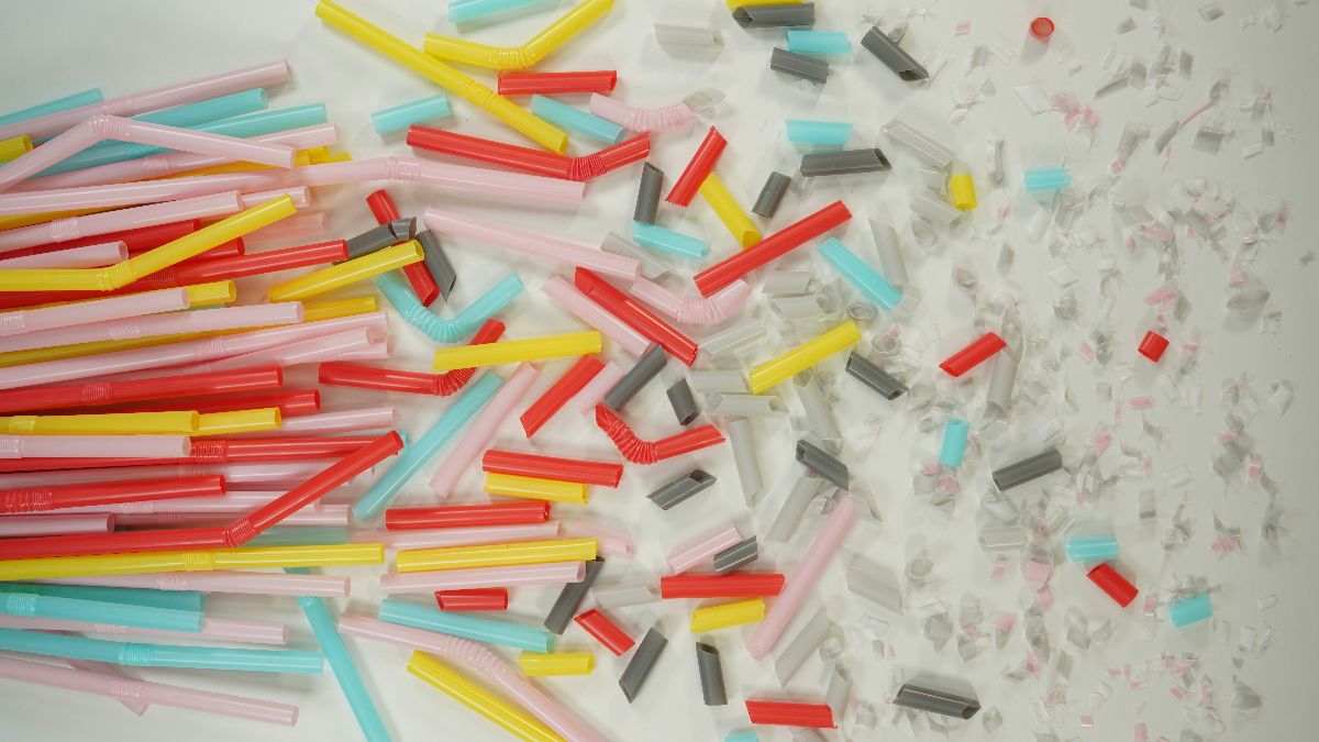 Bunte Plastikstrohhalme und kleine Plastikfragmente als Symbol für Mikroplastik, Umweltgifte und männliche Fruchtbarkeit