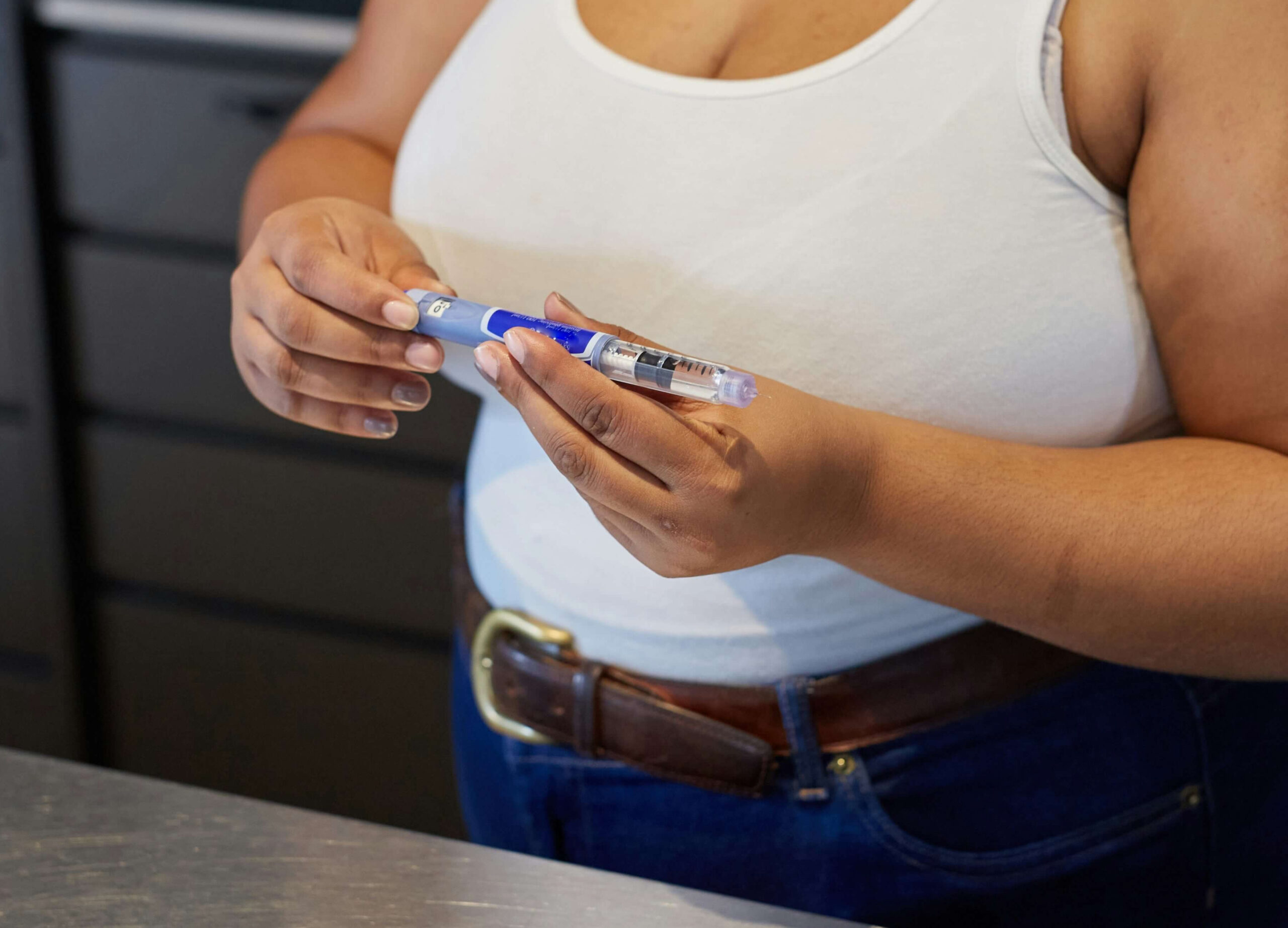 Frau hält GLP-1 Injektionspen zur Gewichtsreduktion in der Hand