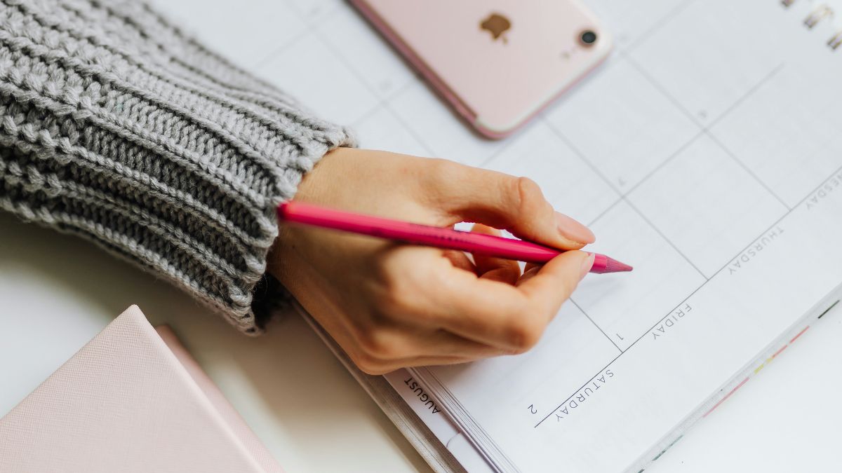 Frau trägt Zyklusdaten in einen Kalender ein