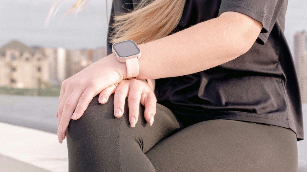 Frau trägt Wearable‑Tracker und überprüft ihre Stoffwechseldaten, während sie sich auf eine Schwangerschaft vorbereitet