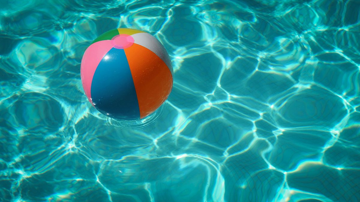 Bunter Wasserball im Pool als Symbol für Sommer, Hitze, Urlaub und Spermienqualität beim Kinderwunsch