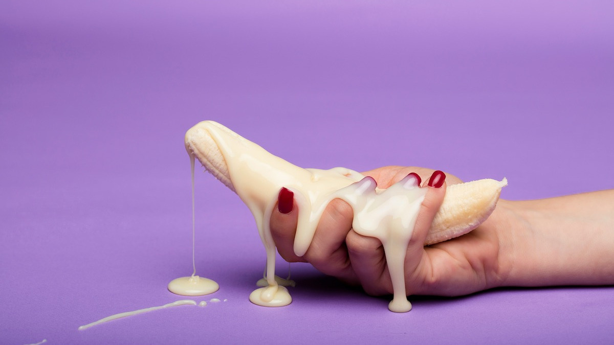 Symbolbild männliche Fruchtbarkeit – Banane mit weißer Flüssigkeit als Darstellung von Spermien und Ejakulation