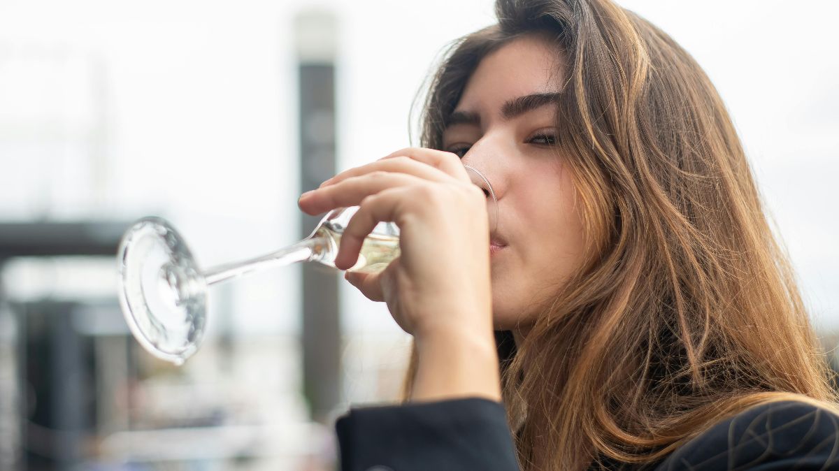 Junge Frau trinkt aus einem Weinglas – symbolisch für den Einfluss von Alkohol auf Mikrobiom und Einnistung beim Kinderwunsch