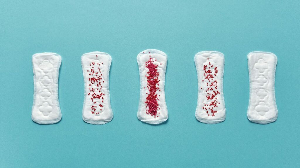 Binden mit roter Markierung als Symbol für Einnistungsblutung, Periode und Kinderwunsch