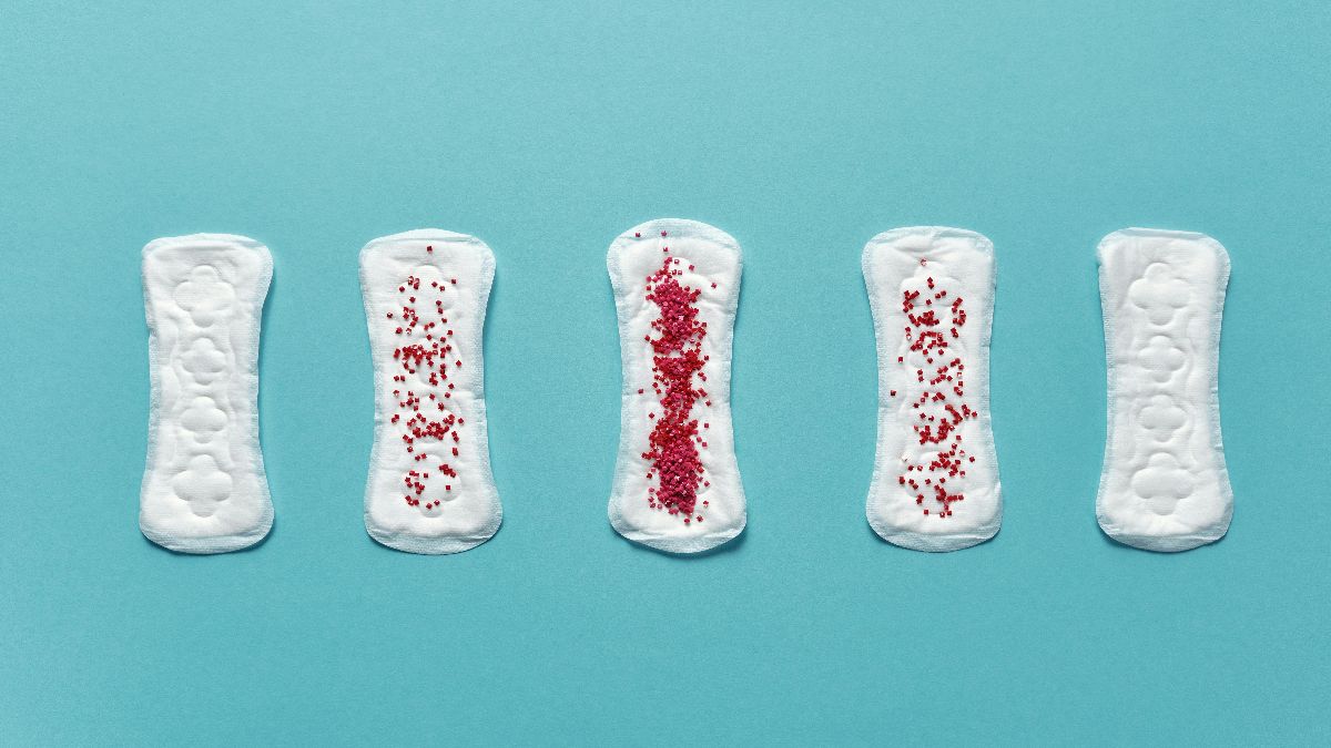 Binden mit roter Markierung als Symbol für Einnistungsblutung, Periode und Kinderwunsch