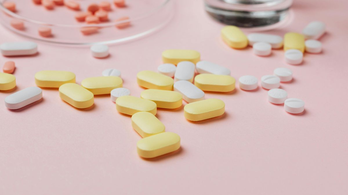 Tabletten und Wasserglas als Symbol für Schmerzmittel, Ibuprofen, Eisprung und Kinderwunsch