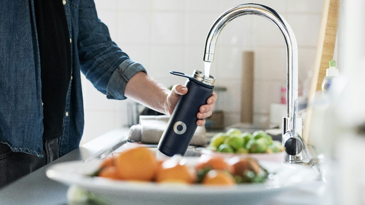 Person füllt eine Trinkflasche mit Leitungswasser als Symbol für PFAS, Trinkwasser und Fruchtbarkeit