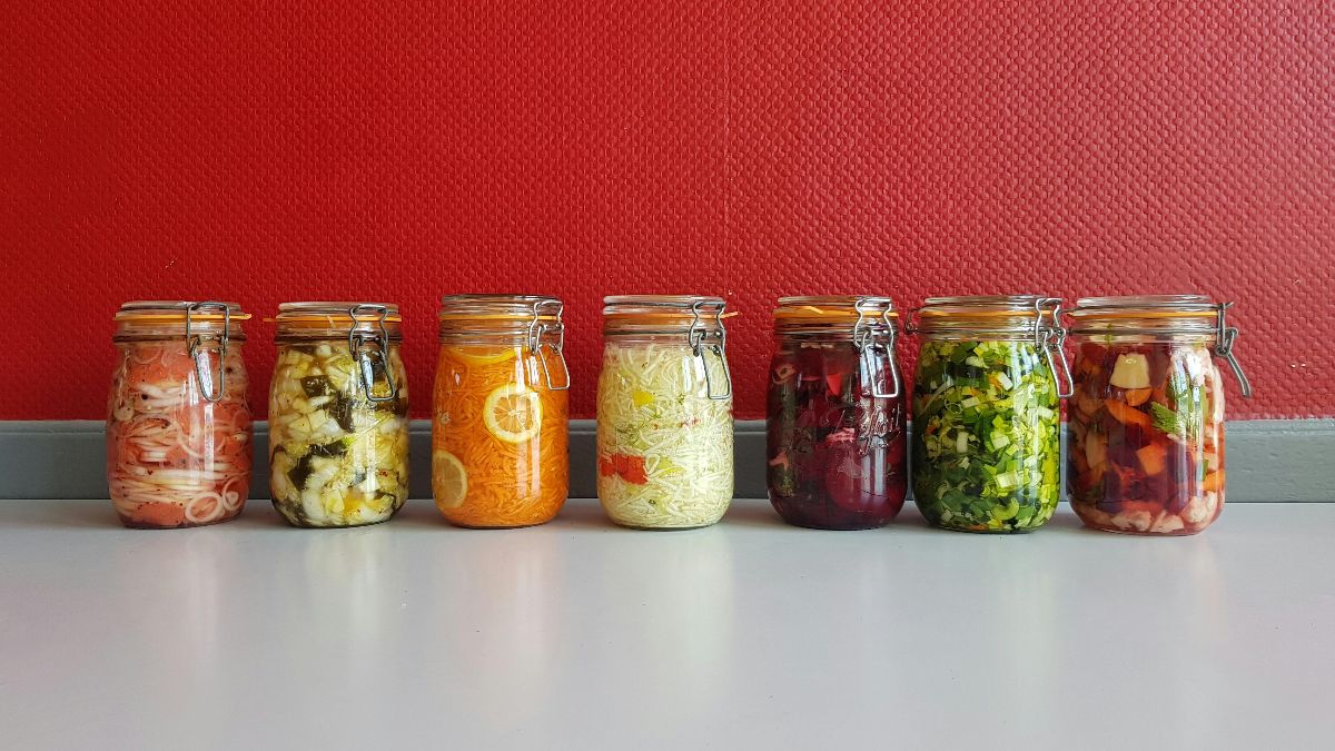 Bunte Gläser mit fermentierten Gemüsen – Sauerkraut, Kimchi und Co. für ein gesundes Darmmikrobiom beim Kinderwunsch