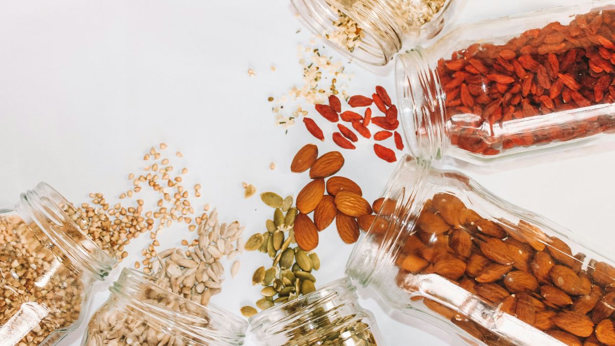Nüsse, Samen und Goji-Beeren in Glasgläsern – magnesiumreiche Lebensmittel für Hormonbalance und Zyklusgesundheit beim Kinderwunsch